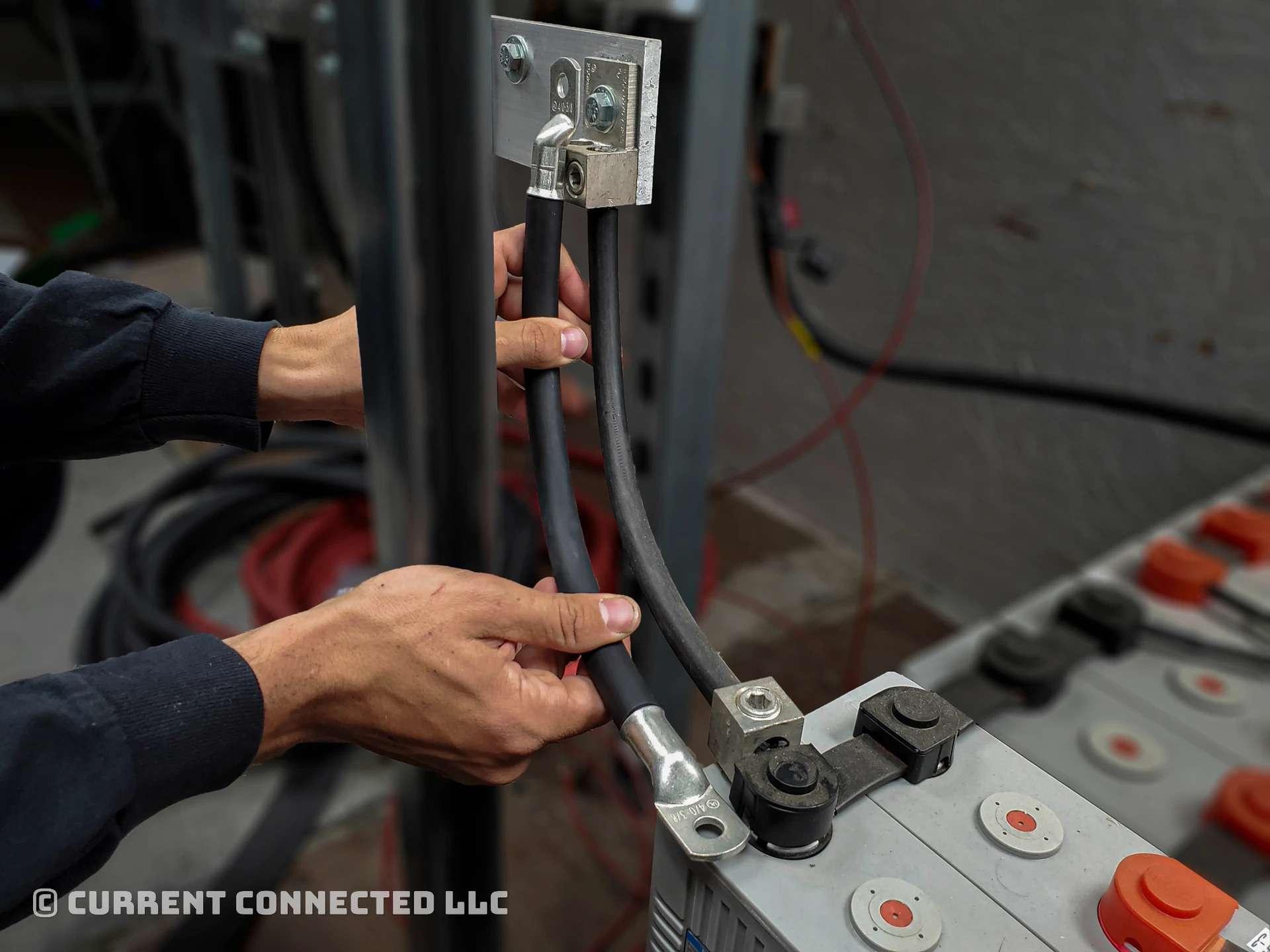 Photo of a cable held between two locations and demonstrating how the lugs must be crimped the correct direction on the cable. 