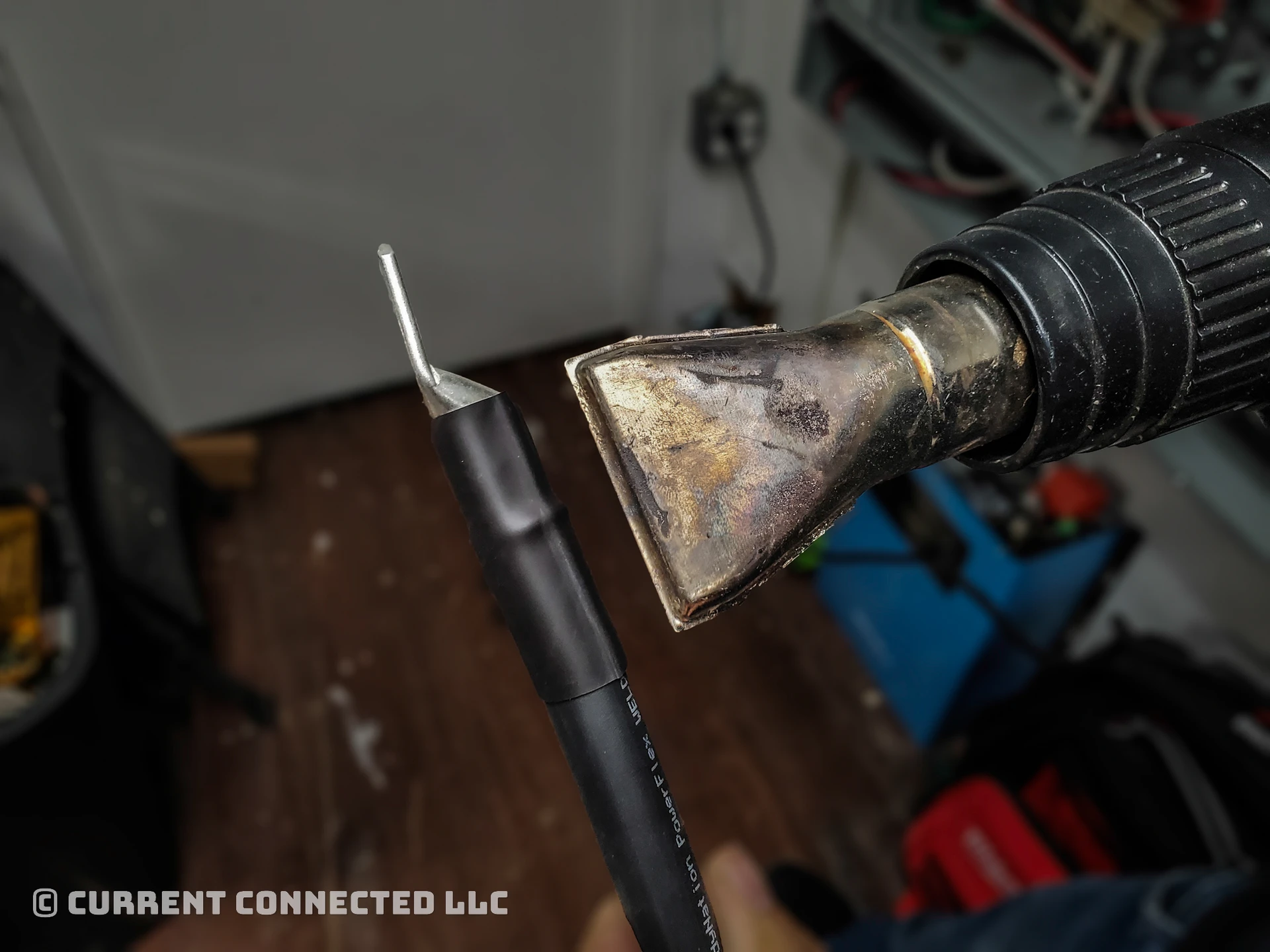 Photo of a heat gun shrinking the tubing on the cable. 