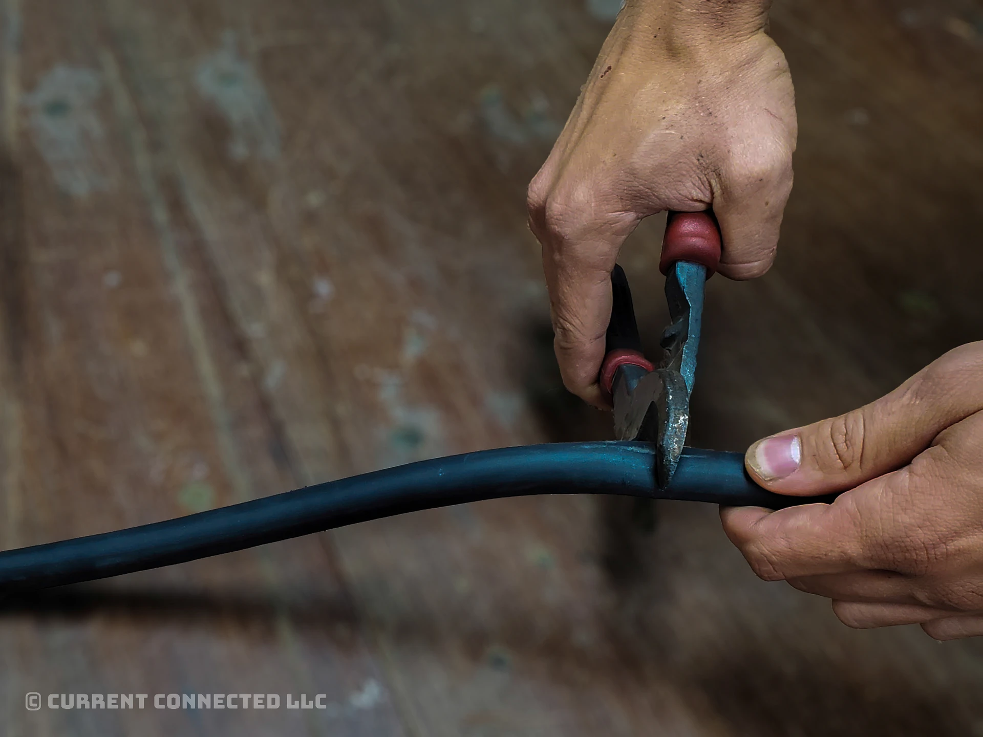 Photo of someone cutting a battery cable.