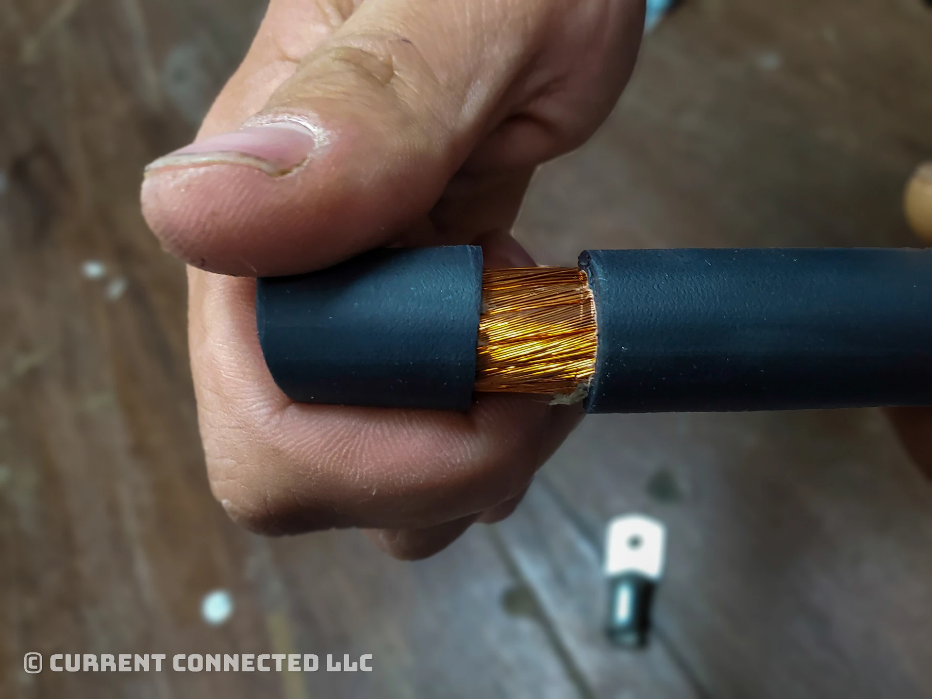 Photo of someone pulling the insulation off a wire. 